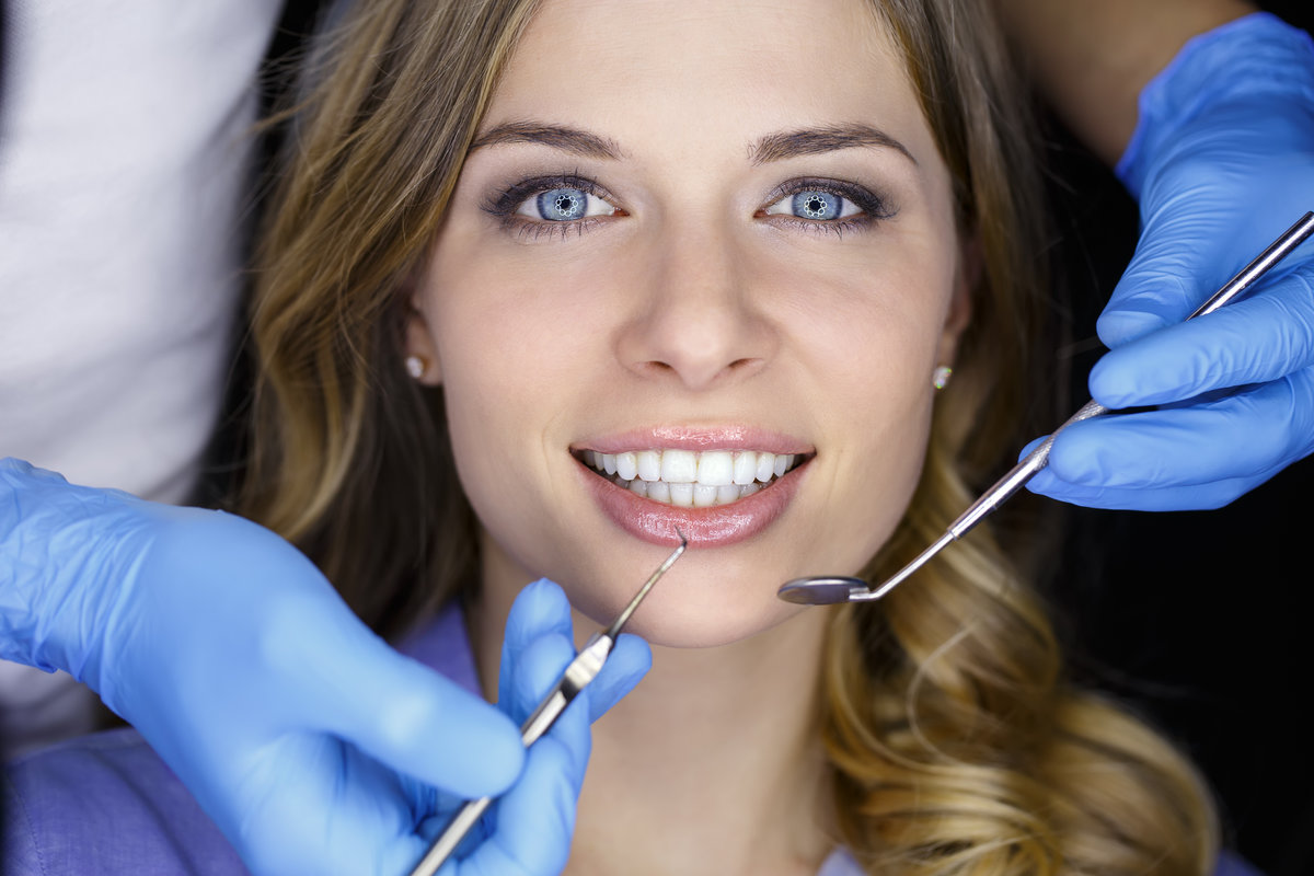 Girl with beautiful white teeth on reception at the doctor dentist.